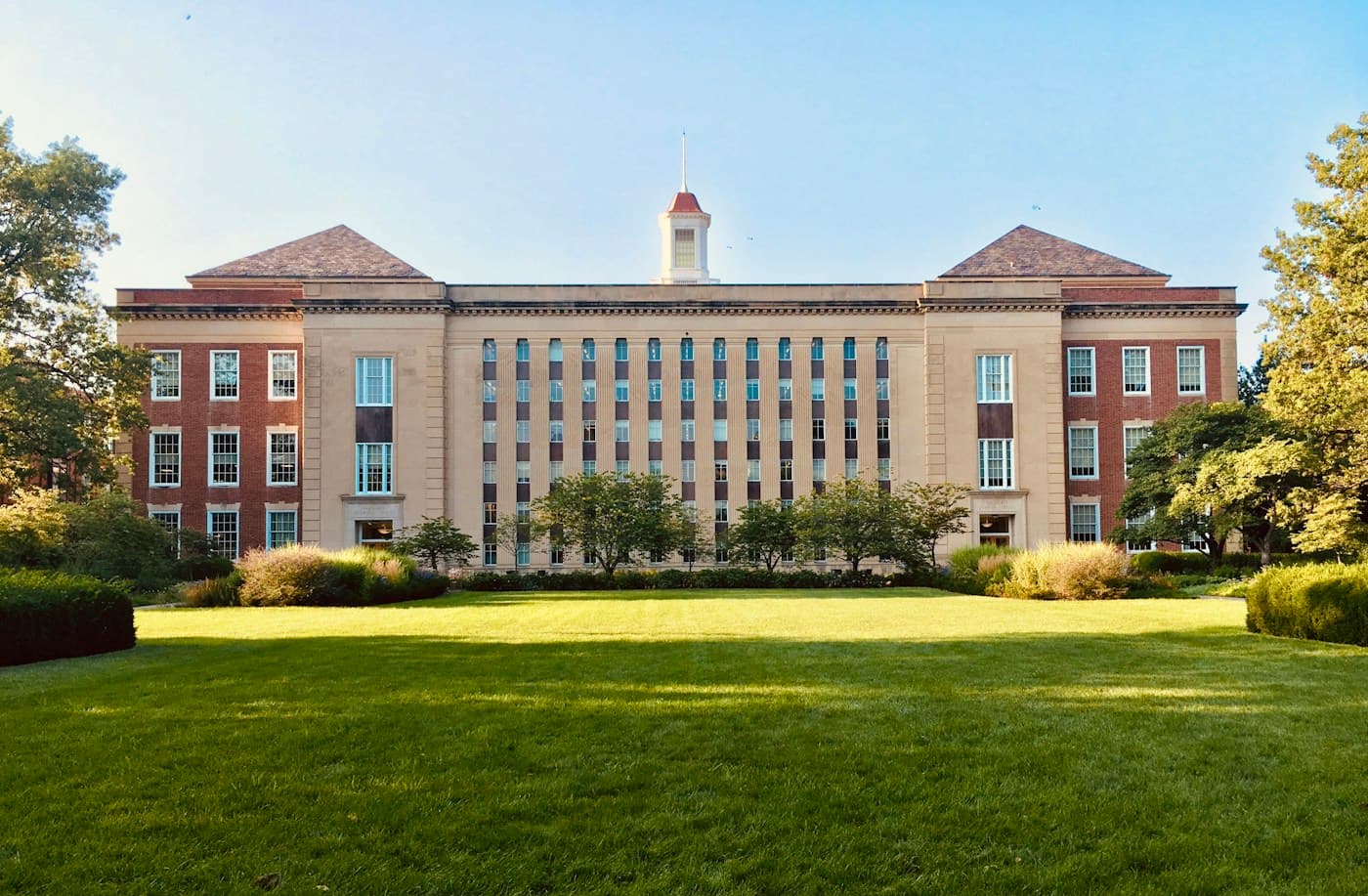A college building overlooking a green campus lawn