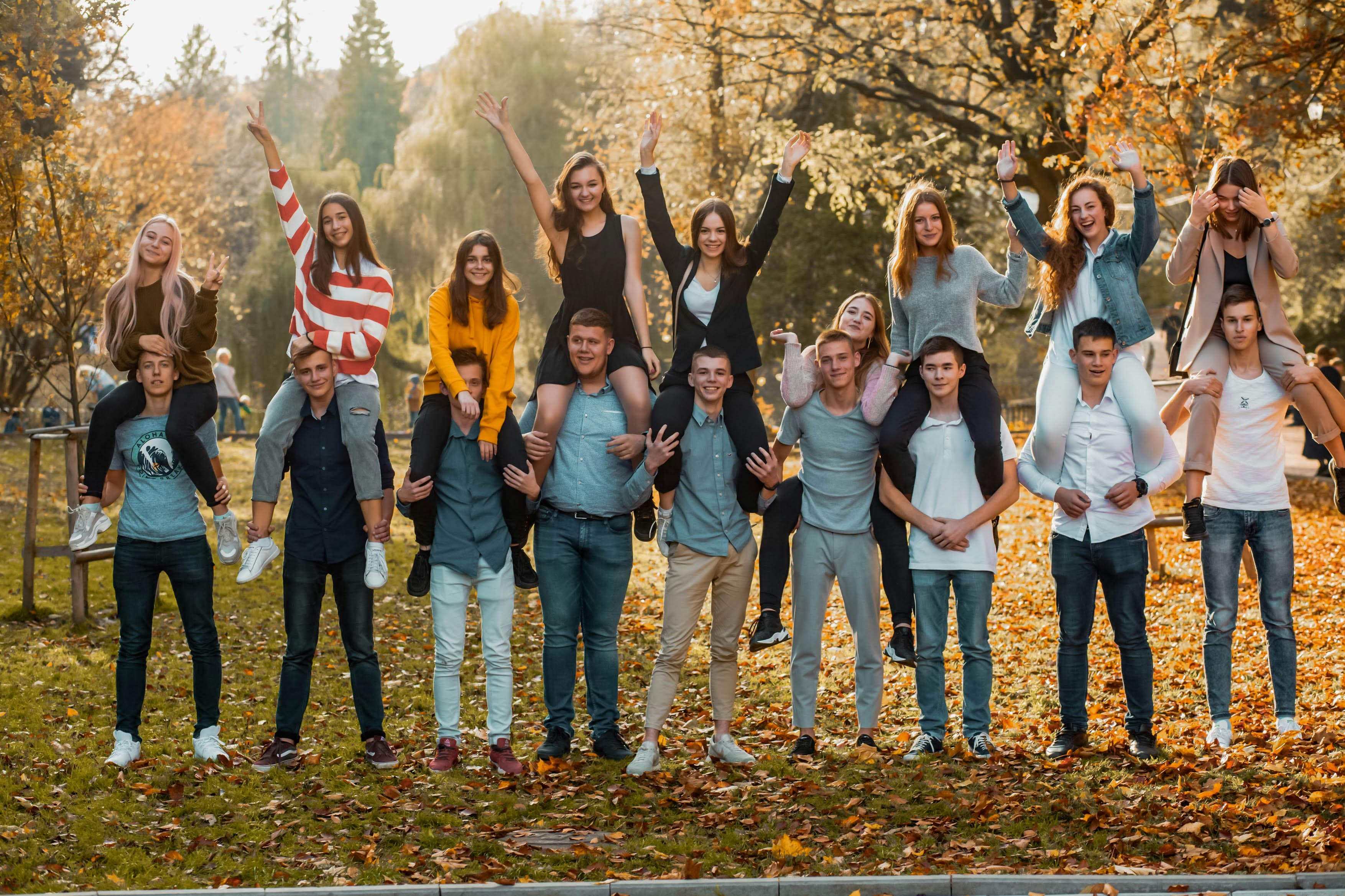 A group of students gathered outdoors among autumn trees